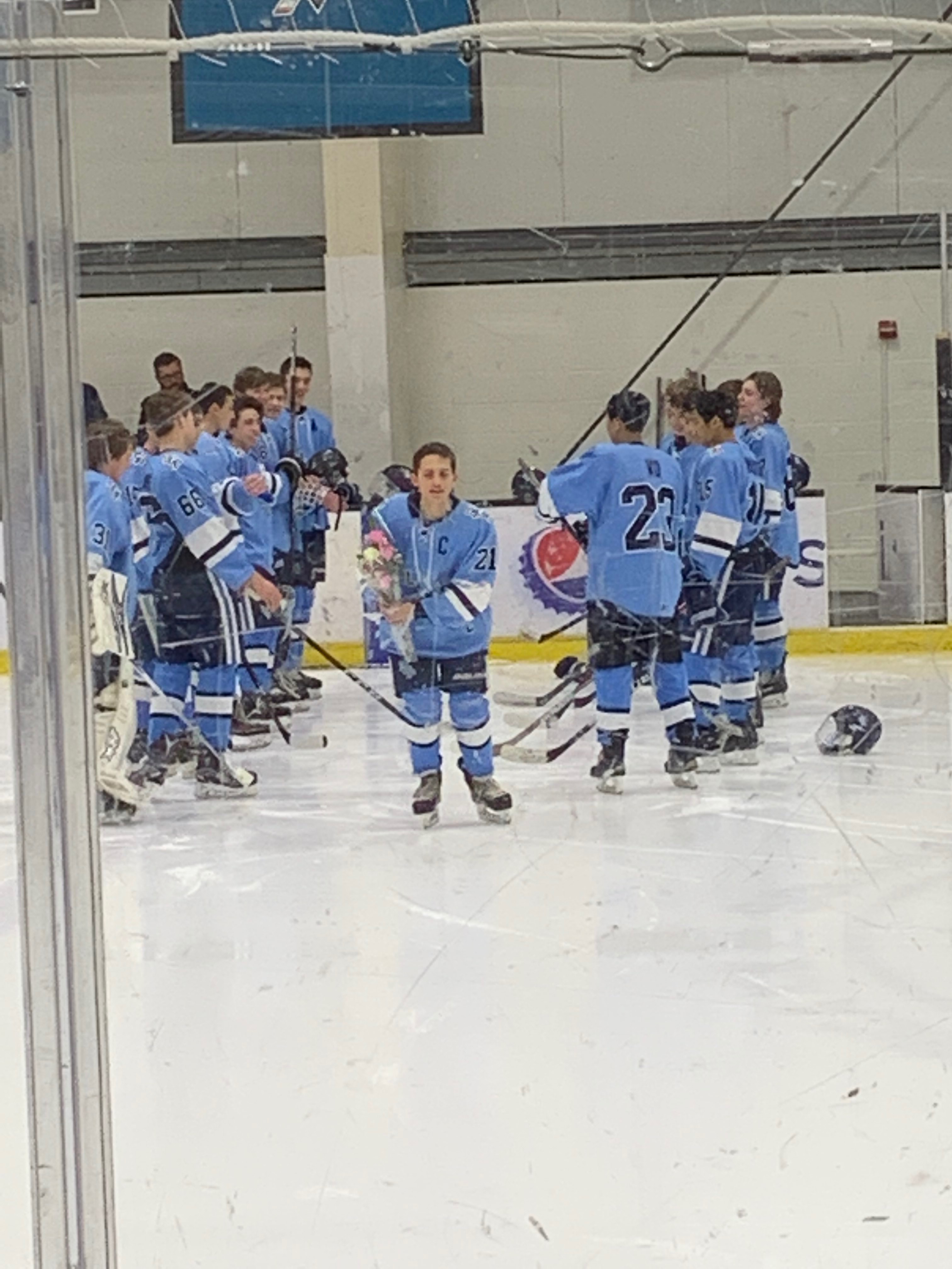 Senior Captain Griffin Buerk enters the ice with a rose for his mom.